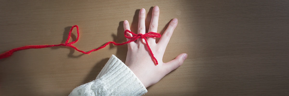 赤い糸で結ばれた薬指の写真