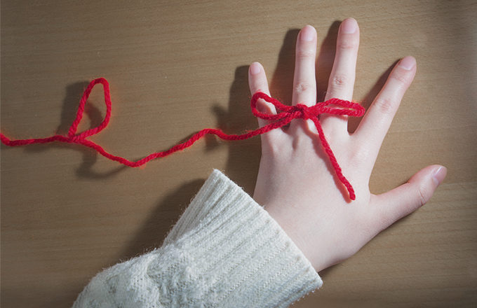 赤い糸で結ばれた手の写真